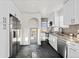 Stylish kitchen featuring black tile flooring, white cabinetry, stainless steel appliances, and stone countertops at 3250 N Clayton St, Denver, CO 80205