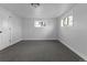 A finished basement bedroom with neutral carpet, white walls, and two bright windows at 6641 Ash St, Commerce City, CO 80022