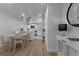 View of the dining area connected to a modern, updated kitchen with white cabinetry at 6641 Ash St, Commerce City, CO 80022