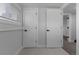 Bright hallway featuring white doors, trim, and floors with modern fixtures and natural light at 6641 Ash St, Commerce City, CO 80022