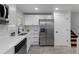 Well-lit kitchen with white cabinets, stainless steel appliances, and modern finishes at 6641 Ash St, Commerce City, CO 80022