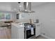 Open concept kitchen with stainless steel appliances, bright countertops, and view into the living room at 6641 Ash St, Commerce City, CO 80022