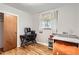 Bedroom featuring hardwood floors, a work desk, an orange beanbag chair, and a closet at 13558 E Center Ave, Aurora, CO 80012