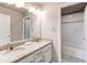 Well-lit bathroom features a double sink vanity with granite countertop and a tiled shower-tub combination at 15920 Hayloft Ln, Parker, CO 80134
