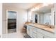 Bathroom featuring a double sink vanity, granite countertop and large mirror at 15920 Hayloft Ln, Parker, CO 80134