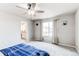 Bright bedroom featuring neutral carpet, a ceiling fan, a large window, and an ensuite bathroom at 15920 Hayloft Ln, Parker, CO 80134