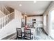 Open dining area with stairs, modern white kitchen, grey floors, and sliding glass door to the patio at 15920 Hayloft Ln, Parker, CO 80134