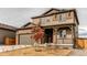 Two-story home with brown siding, stone accents, covered porch, and attached garage at 15920 Hayloft Ln, Parker, CO 80134