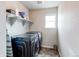 Modern laundry room with front loading washer and dryer and a storage shelf at 15920 Hayloft Ln, Parker, CO 80134