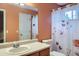 Bathroom with a flower-themed shower curtain, white fixtures, and a large mirror over the sink at 401 W 114Th Pl, Northglenn, CO 80234