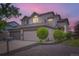 Charming home with a two-car garage, gray brick accents, and well-maintained landscaping at dusk at 401 W 114Th Pl, Northglenn, CO 80234