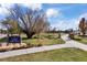 Sign for City of Arvada's Griffith Station Park with walking path and large tree on a sunny day at 8410 W 52Nd Ave, Arvada, CO 80002