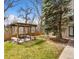Landscaped backyard features a wooden pergola with seating area and lush lawn at 1607 Cottonwood Dr # 14, Louisville, CO 80027