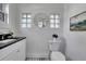 Stylish powder room features black and white checkered floors, vessel sink, and decorative round mirror and art at 1343 Milwaukee St, Denver, CO 80206