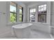 Bright bathroom features a soaking tub under large windows at 1343 Milwaukee St, Denver, CO 80206