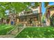 Charming brick home with a covered front porch and lush green lawn at 1343 Milwaukee St, Denver, CO 80206