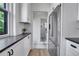 Galley kitchen with stainless steel refrigerator and black countertops; stylish tile flooring leads to adjacent bathroom at 1343 Milwaukee St, Denver, CO 80206