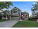 Two-story house with gray siding, brick accents, and a two-car garage at 7291 Palisade Dr, Highlands Ranch, CO 80130