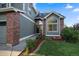 Front entrance of the house with a walkway, landscaping, and a brick accent wall at 7291 Palisade Dr, Highlands Ranch, CO 80130