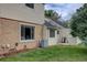 Backyard area featuring lush grass, concrete patio, and exterior of home at 1769 S Lee St # B, Lakewood, CO 80232