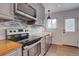Updated kitchen featuring stainless steel appliances, wood counters, and subway backsplash at 1769 S Lee St # B, Lakewood, CO 80232