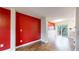 Spacious living room with wood floors, a vibrant red wall, and a sliding glass door to the outside at 7682 S Steele St, Centennial, CO 80122