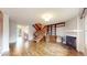 Bright and open living room with hardwood floors, a cozy fireplace, and a staircase at 7682 S Steele St, Centennial, CO 80122