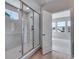 Bathroom featuring glass enclosed shower and open door to a bedroom at 8585 Eckley St, Littleton, CO 80125