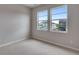 Bedroom features neutral carpet, white baseboards, and a double window for natural light at 8585 Eckley St, Littleton, CO 80125