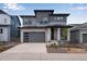 Attractive two-story home with a stone-accented facade, gray siding, and a spacious two car garage at 8585 Eckley St, Littleton, CO 80125