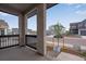 Inviting covered front porch featuring stone columns, black railings and views of the neighborhood at 8585 Eckley St, Littleton, CO 80125