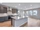 Bright, open kitchen with stainless steel appliances, an island with a sink and light hardwood floors at 8585 Eckley St, Littleton, CO 80125