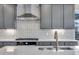 Close up of modern kitchen featuring stainless steel vent hood and gas cooktop at 8585 Eckley St, Littleton, CO 80125