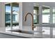 Kitchen sink with white countertop, modern gold faucet and view of neighborhood at 8585 Eckley St, Littleton, CO 80125