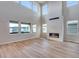 Living room with soaring ceilings, fireplace, and hardwood flooring with lots of natural light at 8585 Eckley St, Littleton, CO 80125