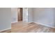 Bright, neutral living room showing wood-look floors, white baseboards, and open doorway at 8585 Eckley St, Littleton, CO 80125
