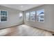 Sun-filled living room with wood-look floors, neutral walls, and multiple windows at 8585 Eckley St, Littleton, CO 80125