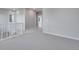 Neutral loft area features gray carpet, white railing, and a view to the staircase at 8585 Eckley St, Littleton, CO 80125