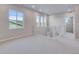 Spacious loft area with neutral carpet, white railing, and ample natural light from multiple windows at 8585 Eckley St, Littleton, CO 80125