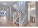 Bright, carpeted staircase with adjacent half bath and hardwood floors at 8585 Eckley St, Littleton, CO 80125