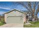 Home with a attached garage, brick accents, and a well-manicured lawn at 9125 W 95Th Ave, Westminster, CO 80021