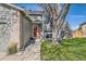 View of a home's covered front entrance with a bright red door and manicured lawn at 9125 W 95Th Ave, Westminster, CO 80021