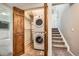 Convenient laundry area with stacked washer/dryer and bi-fold doors, located near the carpeted stairs at 9125 W 95Th Ave, Westminster, CO 80021