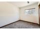 Empty, carpeted room with window featuring wood trim at 9125 W 95Th Ave, Westminster, CO 80021