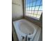 Relaxing soaking tub with tile surround and unique glass block window for natural light at 1148 S Duquesne Cir, Aurora, CO 80018
