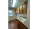 Functional laundry room with ample wood cabinetry, a utility sink, and hardwood flooring at 1148 S Duquesne Cir, Aurora, CO 80018