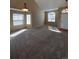 Bright and airy living room with neutral carpet, large windows, and modern lighting fixtures at 1148 S Duquesne Cir, Aurora, CO 80018