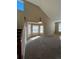 Spacious carpeted living room featuring vaulted ceilings, natural light, and modern lighting fixture at 1148 S Duquesne Cir, Aurora, CO 80018