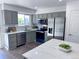 Modern kitchen features gray cabinetry, stainless steel appliances, quartz countertops, and white subway tile at 4382 S Xenon St, Morrison, CO 80465