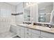 Bright bathroom with double vanity, white cabinets, granite counters, and elegant tile in shower and flooring at 7524 Pineridge Trl, Castle Pines, CO 80108